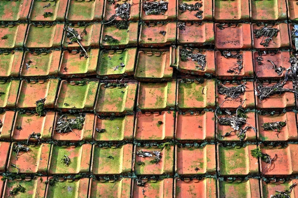 Stos wysokiej jakości czerwonych dachówek ceramicznych na placu budowy nowoczesnego domu.